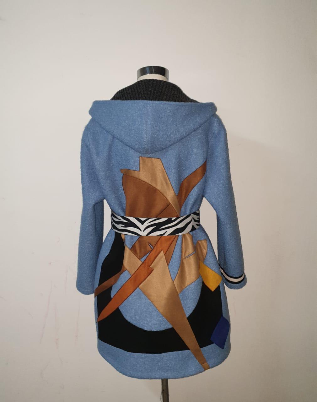 Blue hooded coat with abstract pattern on a mannequin against a plain background