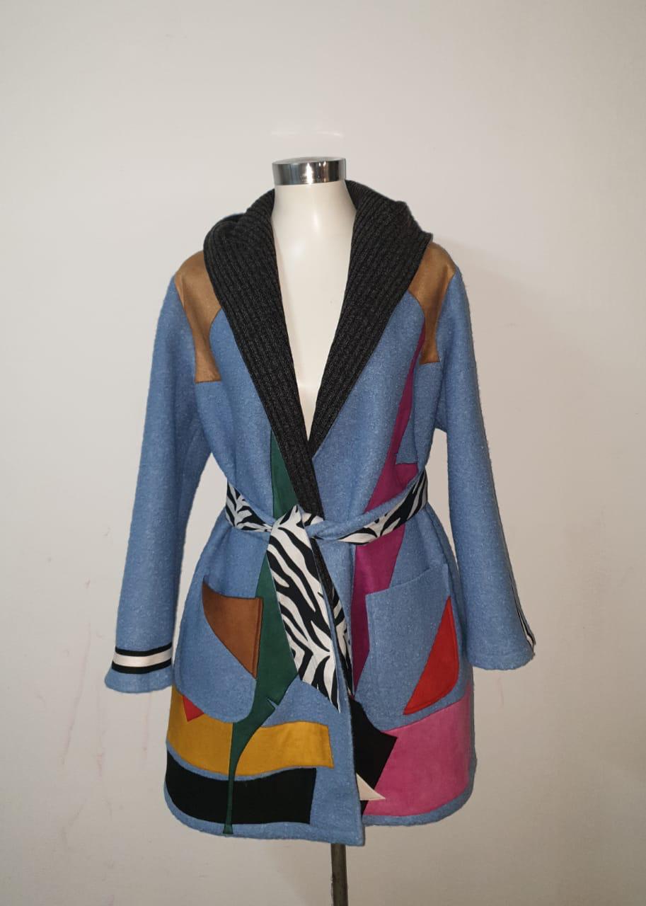 Colorful patchwork coat on a mannequin against a plain background