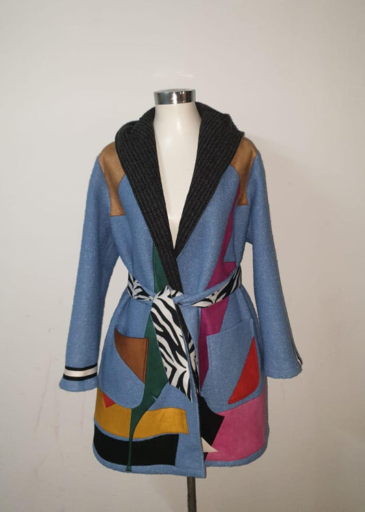 Colorful patchwork coat on a mannequin against a plain background