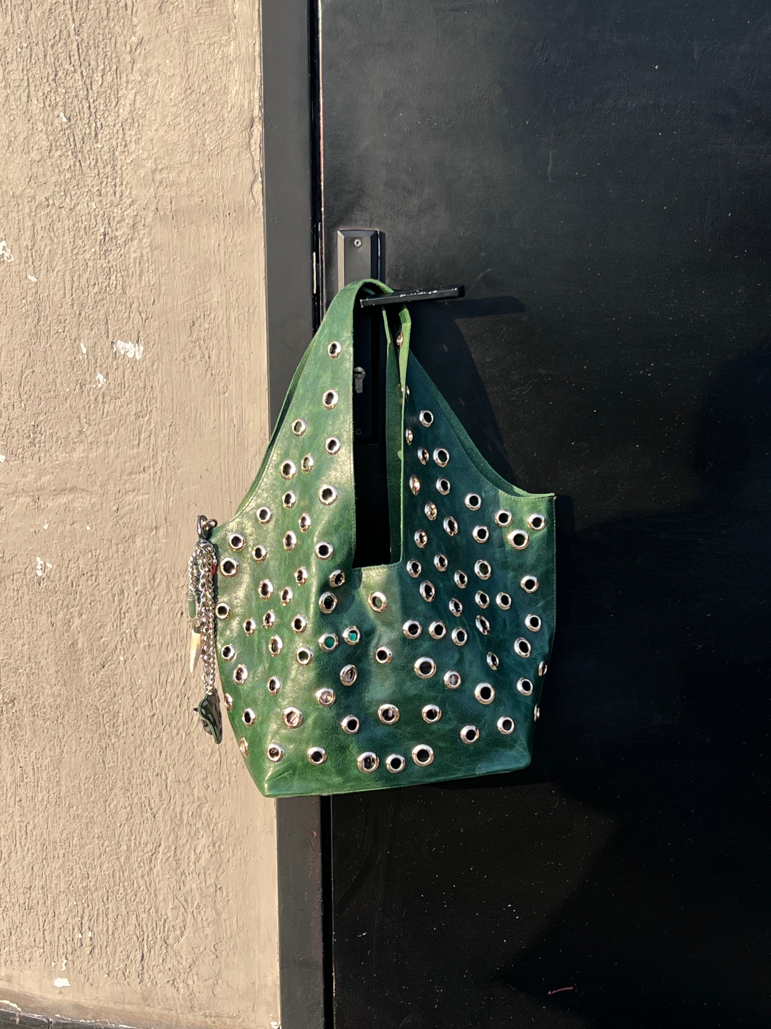 Green studded bag attached to a black door