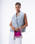 Woman holding a pink metallic handbag against a white background